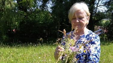 Allgäuer Blumenwiesen: Ingrid Greifenhagen mit einem Sträußchen Wildblumen aus dem eigenen Garten | Bild: Galina Kirsunova