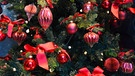 Rote Schleifen und rote Kugeln an einem Weihnachtsbaum | Bild: mauritius images / Studio Barcelona / Alamy / Alamy Stock Fotos