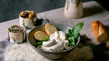 Traditionelle italienische Burrata auf einem Teller mit Brot angerichtet | Bild: mauritius images / CuboImages / Natasha Breen