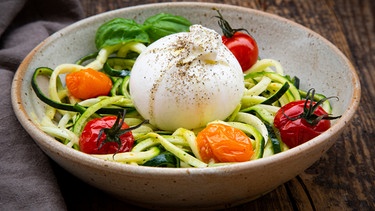 Traditionelle italienische Burrata auf einem Teller Zucchini-Nudeln angerichtet | Bild: mauritius images / Westend61 / Larissa Veronesi