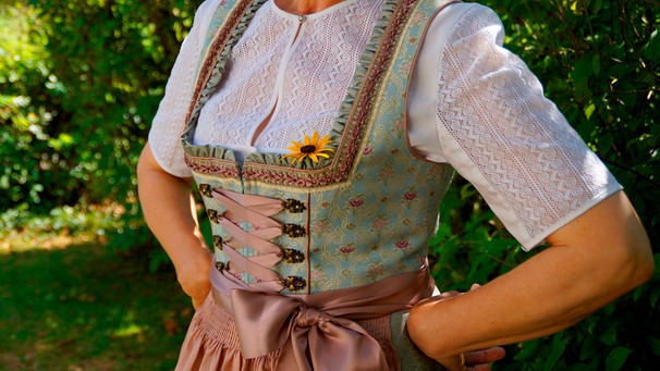 Eine Frau im Dirndl stützt die Hände in die Hüfte | Bild: mauritius images / Julia Färber / Alamy / Alamy Stock Photos