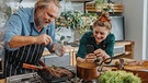 Ein Mann und eine Frau bereiten in einer Küche Fleisch zu | Bild: mauritius images / Westend61 / Mareen Fischinger