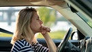 Frau hinter einem Steuer, die im Stau steht und aus dem Fenster blickt | Bild: mauritius images / Dmitry Marchenko / Alamy / Alamy Stock Photos