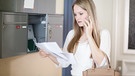 Frau steht vor dem Hausbriefkasten und sieht verärgert auf einen Brief. | Bild: picture alliance / dpa Themendienst | Christin Klose