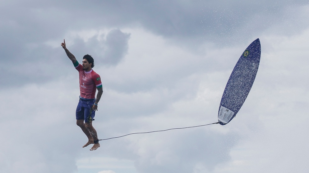 Der brasilianische Surfer Gabriel Medina steht nach einem Wellenritt scheinbar in der Luft. | Bild: picture alliance / Xinhua News Agency | maping