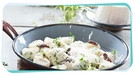 Über eine Pfanne mit Ricotta-Gnocchi mit Kräutern wird frischer Parmesan gehobelt. | Bild: mauritius images / foodcollection