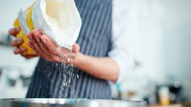 Bäcker gibt Mehl in eine Schüssel | Bild: mauritius images / Dmitriy Shironosov / Alamy / Alamy Stock Photos