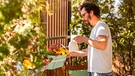 Hobbygärtner besieht sich seine Balkonpflanzen, ob sie von der weißen Fliege befallen sind | Bild: mauritius images /
Pikselstock / Alamy / Alamy Stock Photos