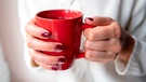 Frau hält eine Tasse Kaffee in den Händen | Bild: mauritius images / Alamy / Tanya Rozhnovskaya