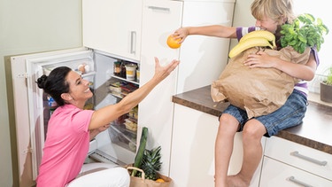 Frau und Kind vor Kühlschrank | Bild: mauritius images /
Cavan Images
/
Robert Niedring