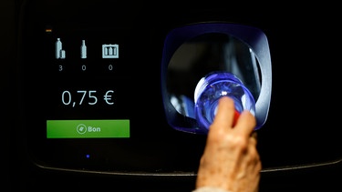 Eine Hand schiebt eine Plastikflasche in einen Leergutautomaten | Bild: picture alliance / Norbert Schmidt | Norbert SCHMIDT