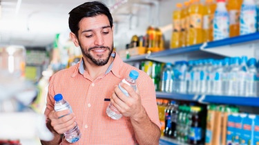 Mann kauft im Supermarkt Wasser ein | Bild: mauritius images / Iakov Filimonov / Alamy / Alamy Stock Photos