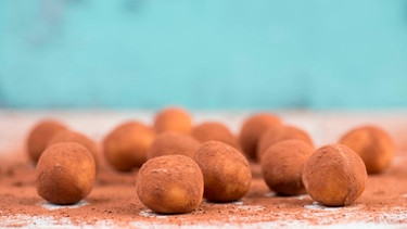 Marzipankartoffeln liegen auf einem Brett mit Kakaopulver. | Bild: mauritius images / Berit Kessler / Alamy / Alamy Stock Photos