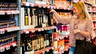 Frau kauft in einem Supermarkt eine Flasche Olivenöl | Bild: mauritius images / Tyler Olson / Alamy / Alamy Stock Fotos