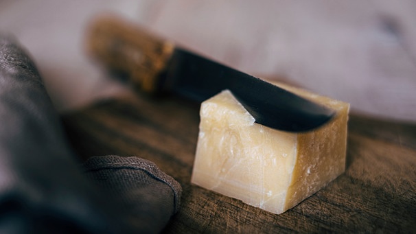 Ein Stück Parmesan auf einem Holzbrett | Bild: mauritius images / EyeEm / Michael Moeller