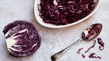 Ein halber Kopf roher Rotkohl und gegarters Rotkraut auf einem flachen Teller | Bild: mauritius images / Mint Images