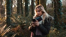 Frau im Wald sendet ihren Standort mit dem Smartphone | Bild: mauritius images / Wavebreak Media Premium / Alamy / Alamy Stock Photos