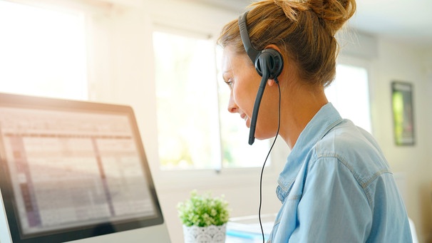 Frau mit Headset betreut Kunden am Telefon | Bild: mauritius images /
GOODLUZ / Alamy / Alamy Stock Photos