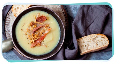 Eine Schüssel mi Topinambursuppe mit Brot auf einem Tisch | Bild: mauritius images / Alamy / Magdalena Bujak /Montage BR