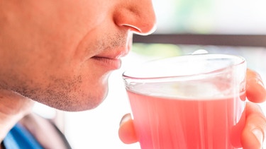 Mann trinkt aus einem Glas Fruchtsaft | Bild: mauritius images / Kristina Blokhin / Alamy / Alamy Stock Photos