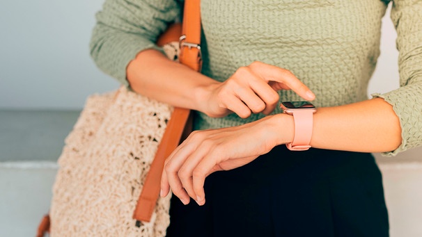 Frau wartet mit Blick auf die Uhr. | Bild: mauritius images / MAKI STUDIO / Alamy / Alamy Stock Photos