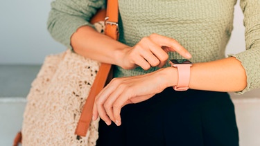 Frau wartet mit Blick auf die Uhr. | Bild: mauritius images / MAKI STUDIO / Alamy / Alamy Stock Photos