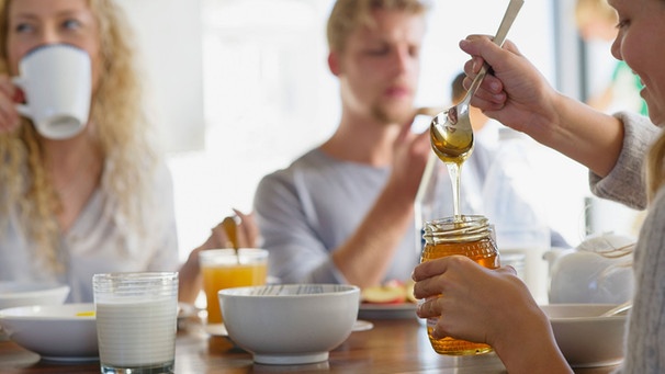 Familie beim Frühstück mit Honigglas | Bild: mauritius images / Onoky