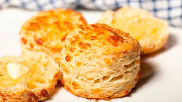 Bild von frischen Scones, mit Käse überbacken und Butter bestrichen | Bild: mauritius images / Robert Downer / Alamy / Alamy Stock Photos