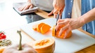 Hände eines Mannes beim Schneiden eines Butternut-Kürbisses | Bild: mauritius images / Prostock-studio / Alamy / Alamy Stock Photos