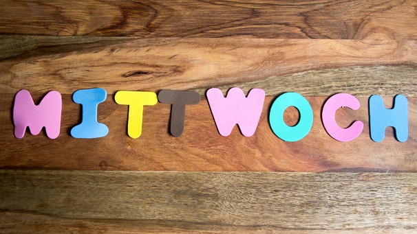 Auf einem Holztisch wurde mit bunten Buchstaben das Wort "Mittwoch" gelegt. | Bild: mauritius images / Pitopia / Daniela Stärk