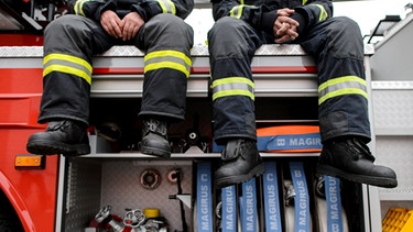 Männer sitzen auf einem Feuerwehrauto | Bild: mauritius images / pa / Robert Schlesinger