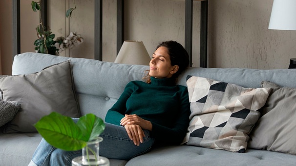 Eine Frau sitzt auf einem Sofa in einem Wohnzimmer
| Bild: mauritius images/ Aleksandr Davydov / Alamy / Alamy Stock Photos