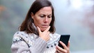 Frau telefoniert besorgt mit ihrem Smartphone | Bild: mauritius images / Antonio Guillem Fernández / Alamy / Alamy Stock Photos