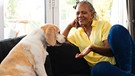 Ein Hund und eine Frau sitzen auf einem Sofa und sie redet mit ihm | Bild: mauritius images / Wavebreak Media Premium / Alamy / Alamy Stock Photos