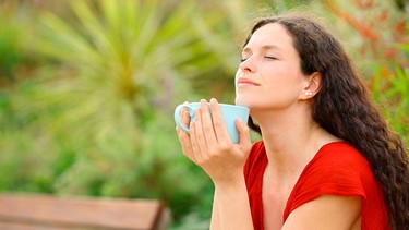 Frau genießt eine Tasse Kaffee im Freien und hat die Augen geschlossen | Bild: mauritius images / Antonio Guillem Fernández / Alamy / Alamy Stock Photos