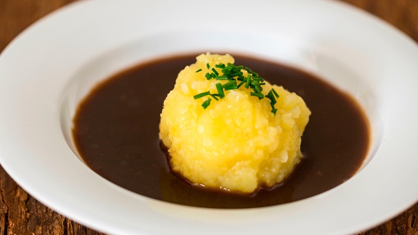 Ein selbst geformter Knödel mit dunkler Bratensoße | Bild: mauritius images / Bernd Jürgens / Alamy / Alamy Stock Photos