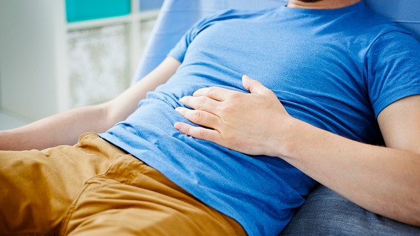 Foto eines Mannes, dessen Magen knurrt. Er hat die Hand auf den Bauch gelegt. | Bild: mauritius images / BSIP / Alice S.