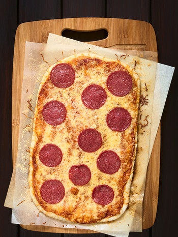 Eine Pizza mit Salami liegt auf einem Teller | Bild: mauritius images / Pitopia / Ildi Papp