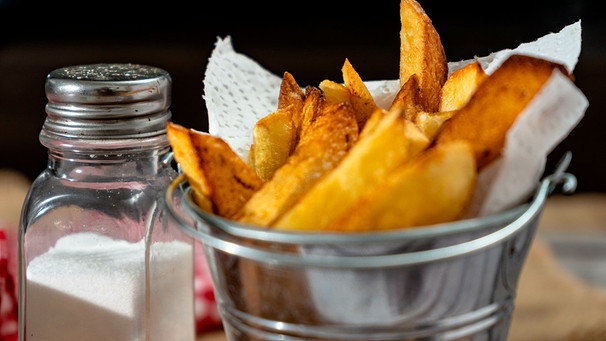 Eine Portion Pommes im Silbertopf mit einem Salzstreuer | Bild: mauritius images / Hernan Caputo / Alamy / Alamy Stock Photos