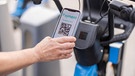 Handy in der Hand einer Frau scannt einen QR-Code | Bild: mauritius images / Westend61 / Aida López