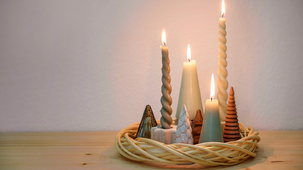 Ein einfacher Adventskranz mit unterscheidlich langen Kerzen und Prozellandeko in einem Kranz aus Weidengeflecht | Bild: mauritius images/ Maren Winter / Alamy / Alamy Stock Photos