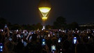 Zahlreiche Schaulustige fotografieren den Ballon mit dem Olympischen Feuer im Tuileriengarten.  | Bild: dpa-Bildfunk/Jan Woitas