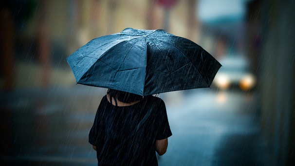 Frau geht mit Regenschirm durch die Stadt | Bild: mauritius images / Lunja / Alamy / Alamy Stock Photos