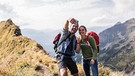 Mann und Frau fotographieren sich auf dem Berg | Bild: mauritius images / Westend61 / Uwe Umstätter