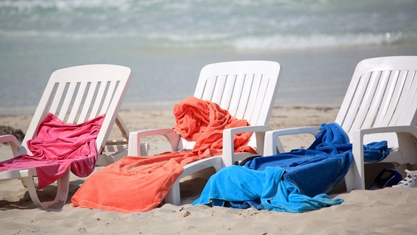 Strandliegestühle mit Handtüchern belegt | Bild: mauritius-images