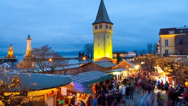 Die Buden stehen bei der Lindauer Hafenweihnacht direkt am Bodensee. | Bild: mauritius images / robertharding / Miles Ertman