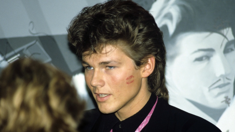 Morten Harket mit rosa Krawatte und Kussmund auf der Wange. | Bild: picture-alliance/dpa