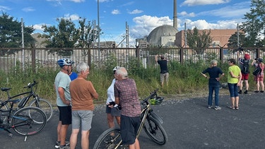 Menschen vor dem ehemaligen Kernkraftwerk Grafenrheinfeld | Bild: BR/Achim Winkelmann