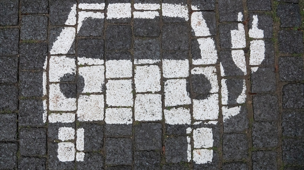 Symbol für ein E-Auto auf dem Boden eines Parkplatzes | Bild: picture-alliance/dpa