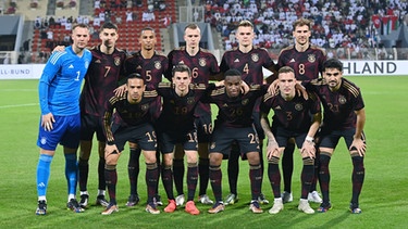 Mannschaftsbild Deutschland; Torwart Manuel Neuer, Kai Havertz, Thilo Kehrer, Lukas Klostermann, Matthias Ginter, Leon Goretzka (hinten v.li) Leroy Sane, Jonas Hofmann, Youssoufa Moukoko, David Raum und Ilkay Guendogan (vorn v.li.) - Aufnahme vom Testspiel am 16. November 2022, Stadion in Oman. | Bild: picture-alliance/dpa/Pressefoto ULMER/Markus Ulmer